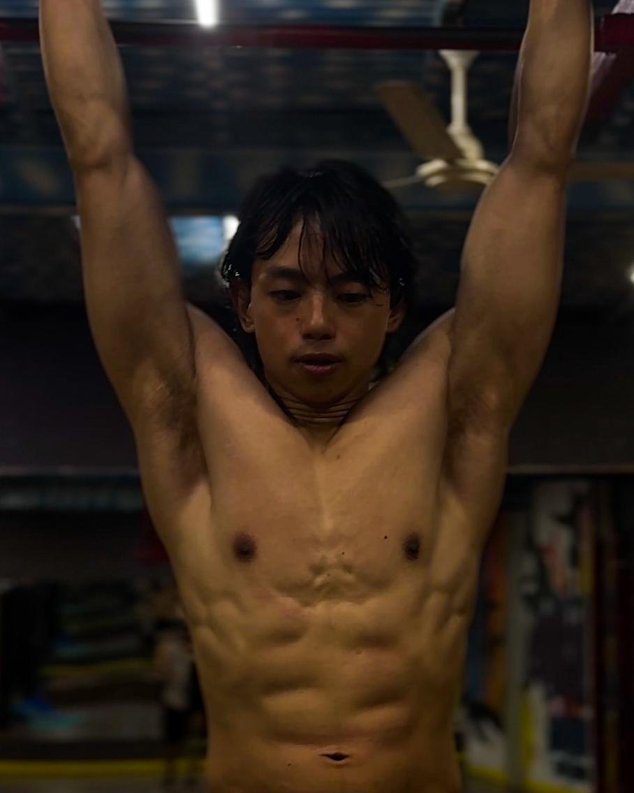 Udip hanging from a pull-up bar, shirtless and visibly leaner, after years on the split