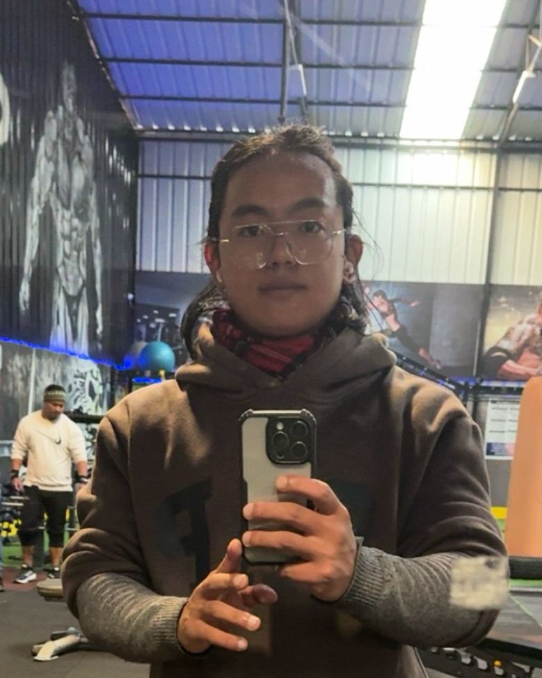 Udip in a hooded sweatshirt, mirror selfie in a gym, before starting the split